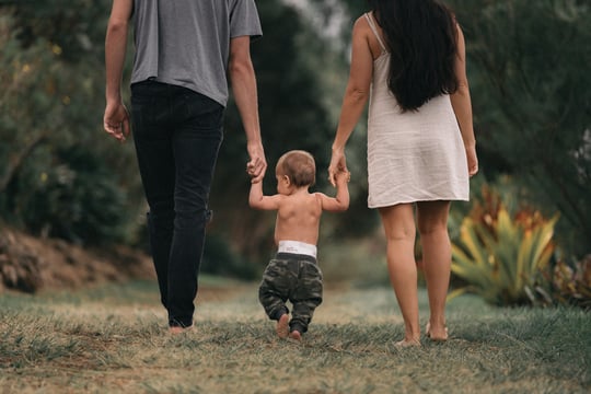 A couple walking with a baby.