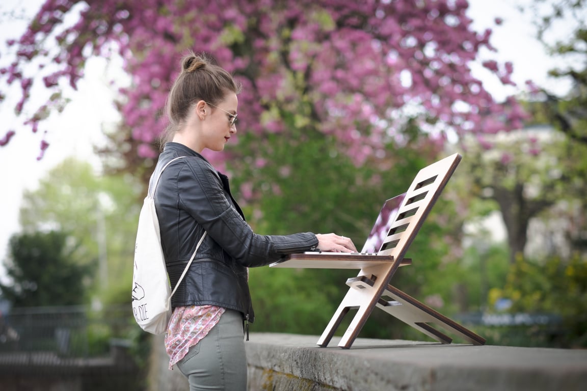 Woman working outdoors on a standing desk.